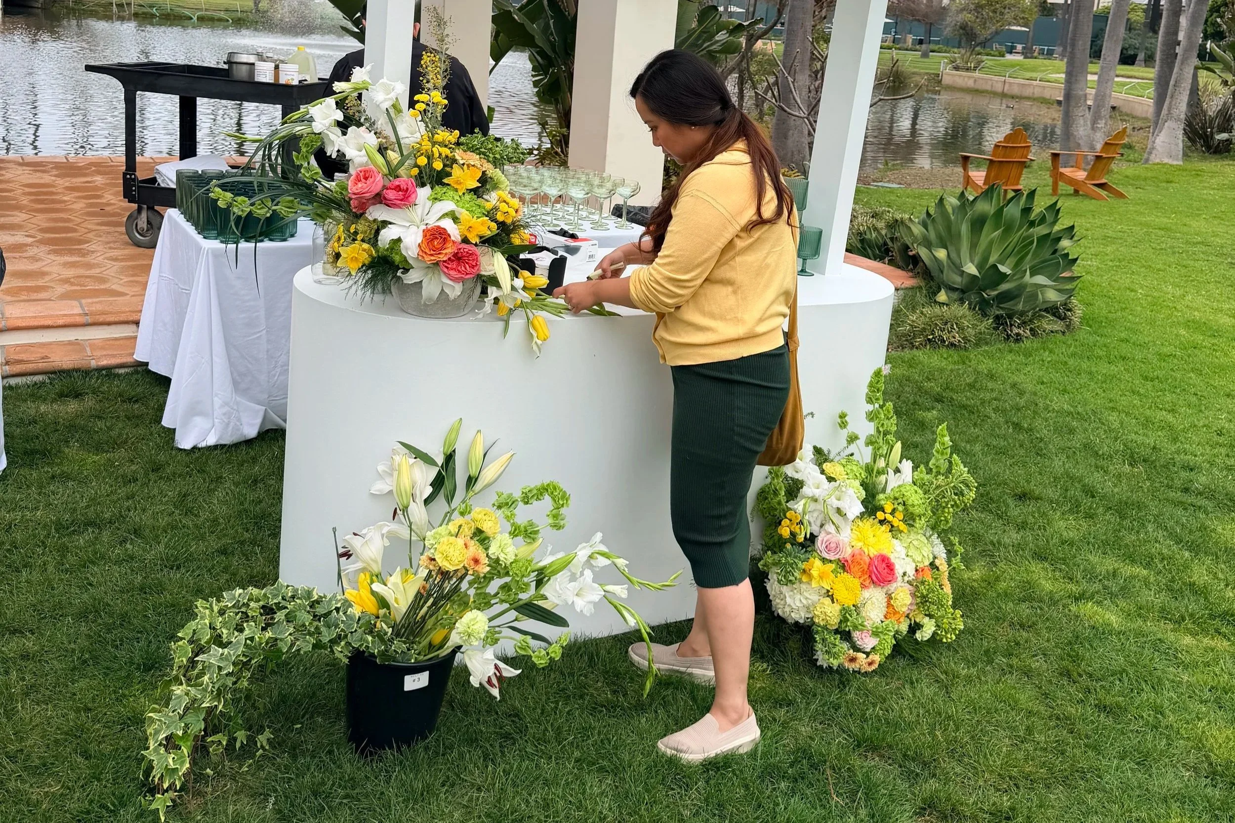 Florist arranging wedding flowers at an outdoor venue, part of hiring a wedding florist in San Diego