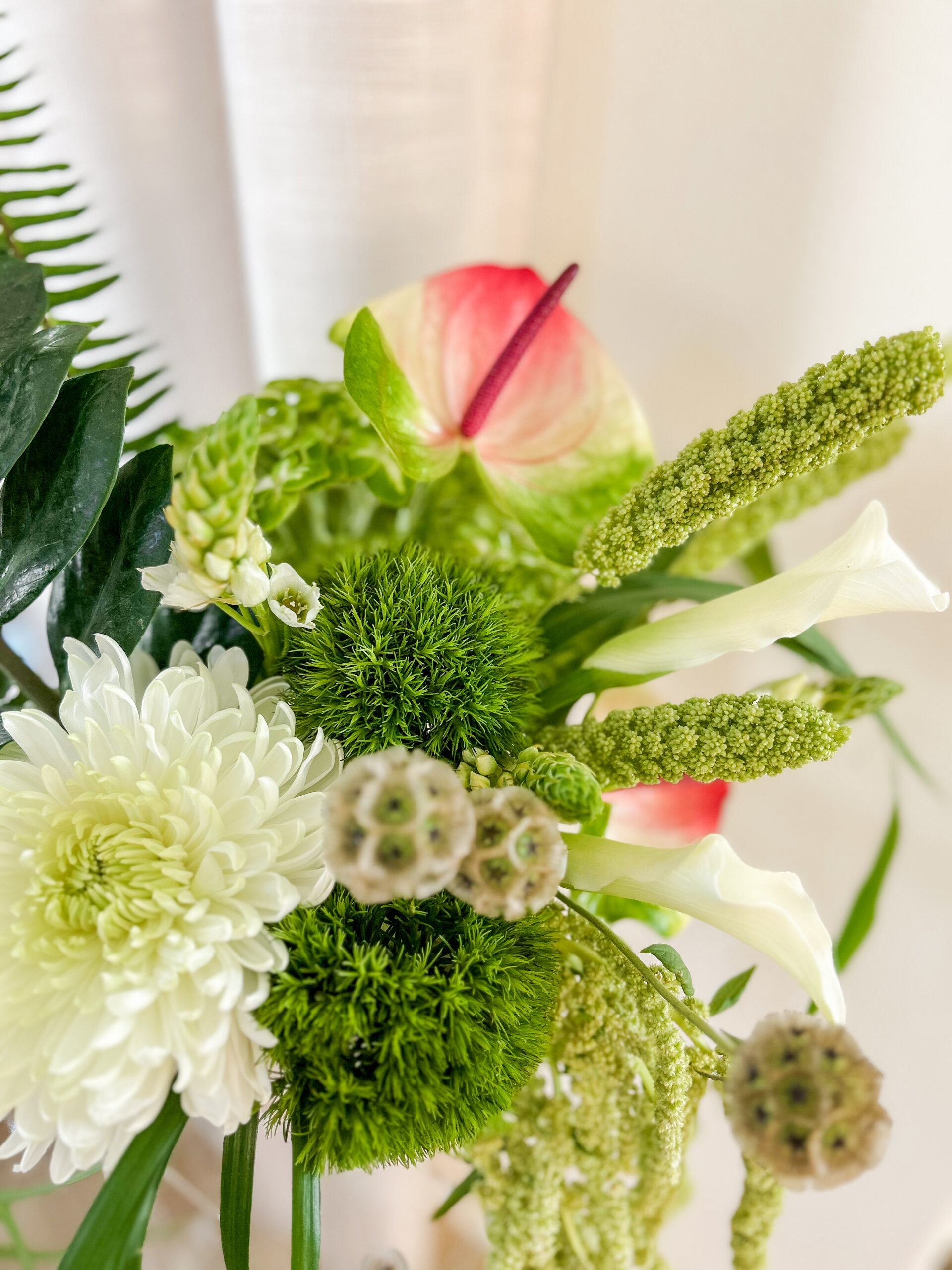 Pink and white anthurium, chrysanthemums, and calla lily in a moody seasonal wedding flowers October wedding bouquet