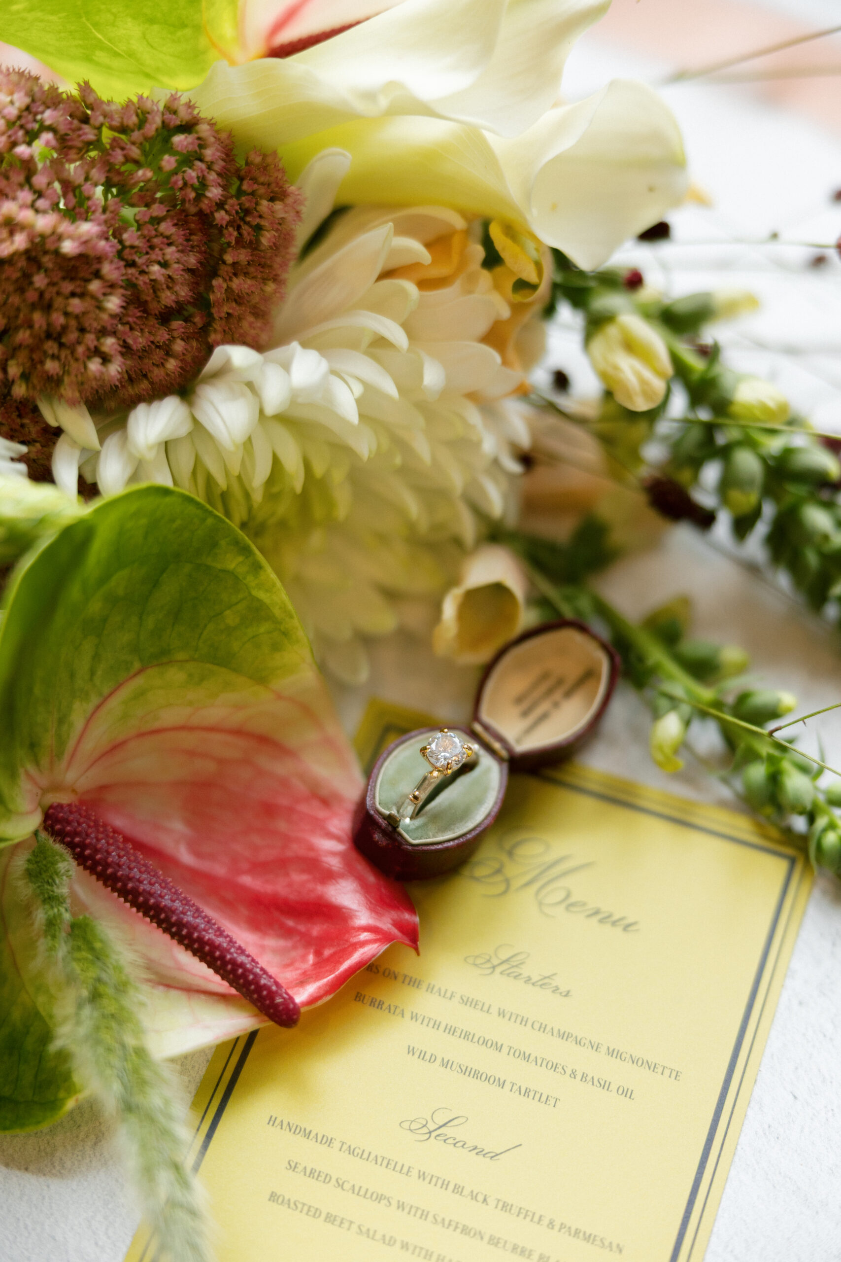 Ring box with sedum, chrysanthemum, and anthurium in a fall-inspired flat lay