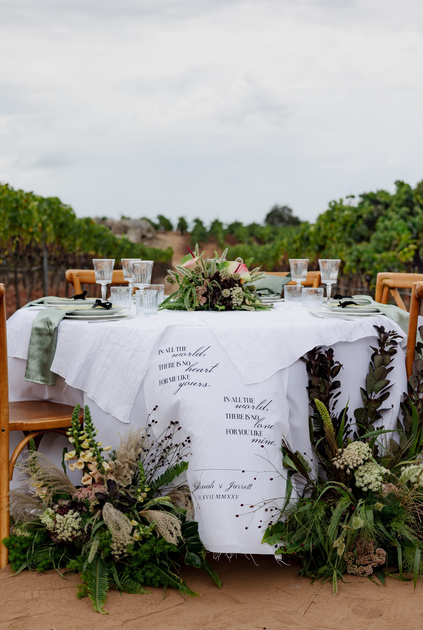 Fall wedding table setting with dried florals and greenery along the linens