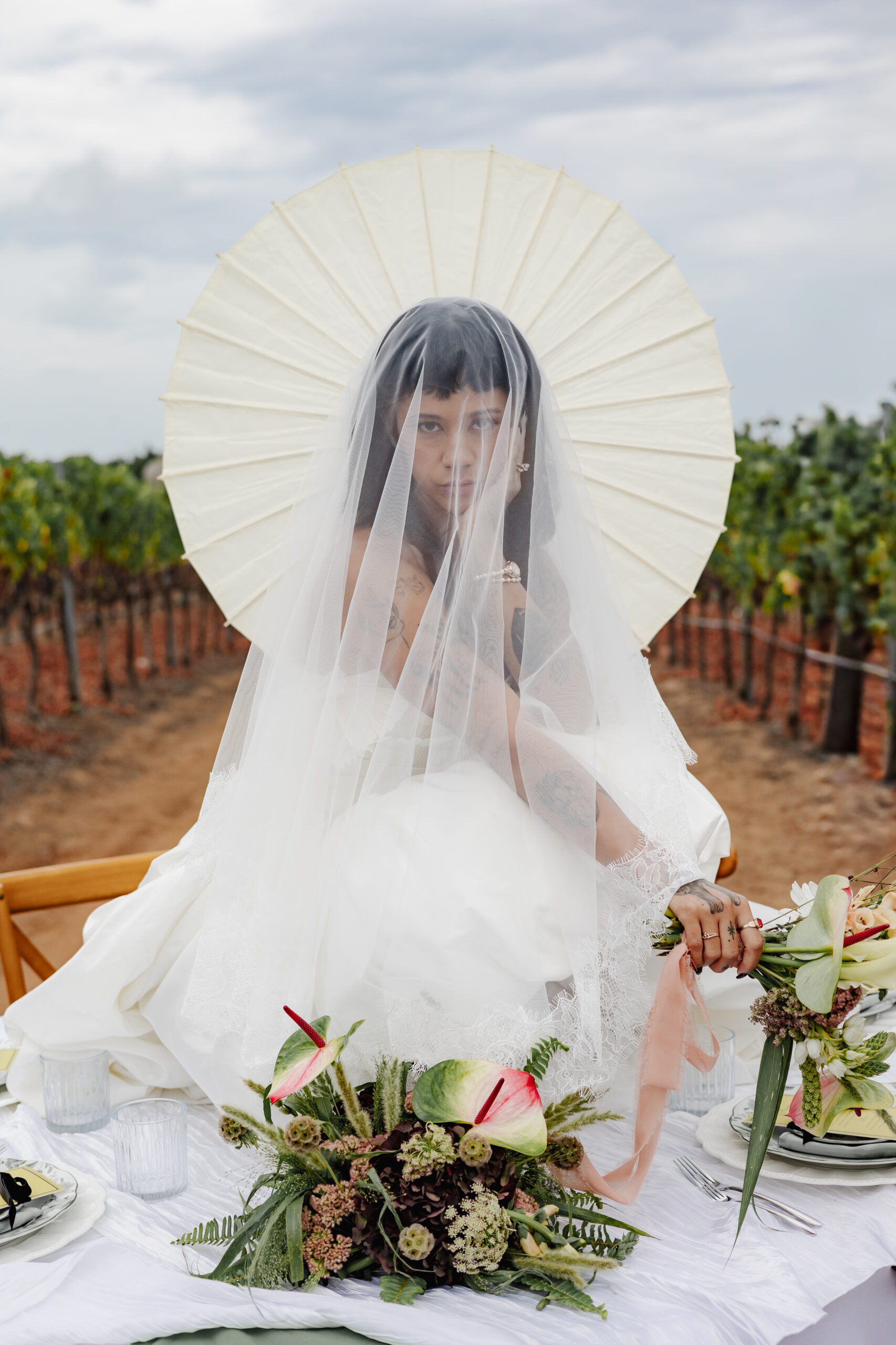 Bridal portrait at a vineyard styled shoot with an anthurium and calla lily bouquet