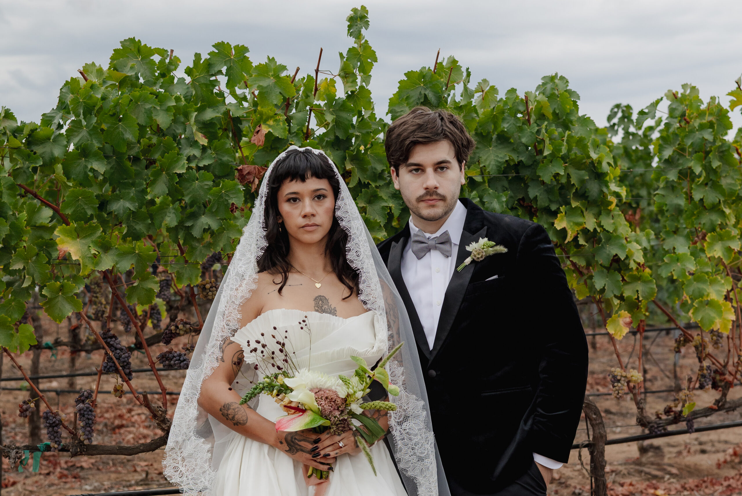 Vineyard wedding portrait featuring a bouquet with anthurium, calla lily, and dried florals