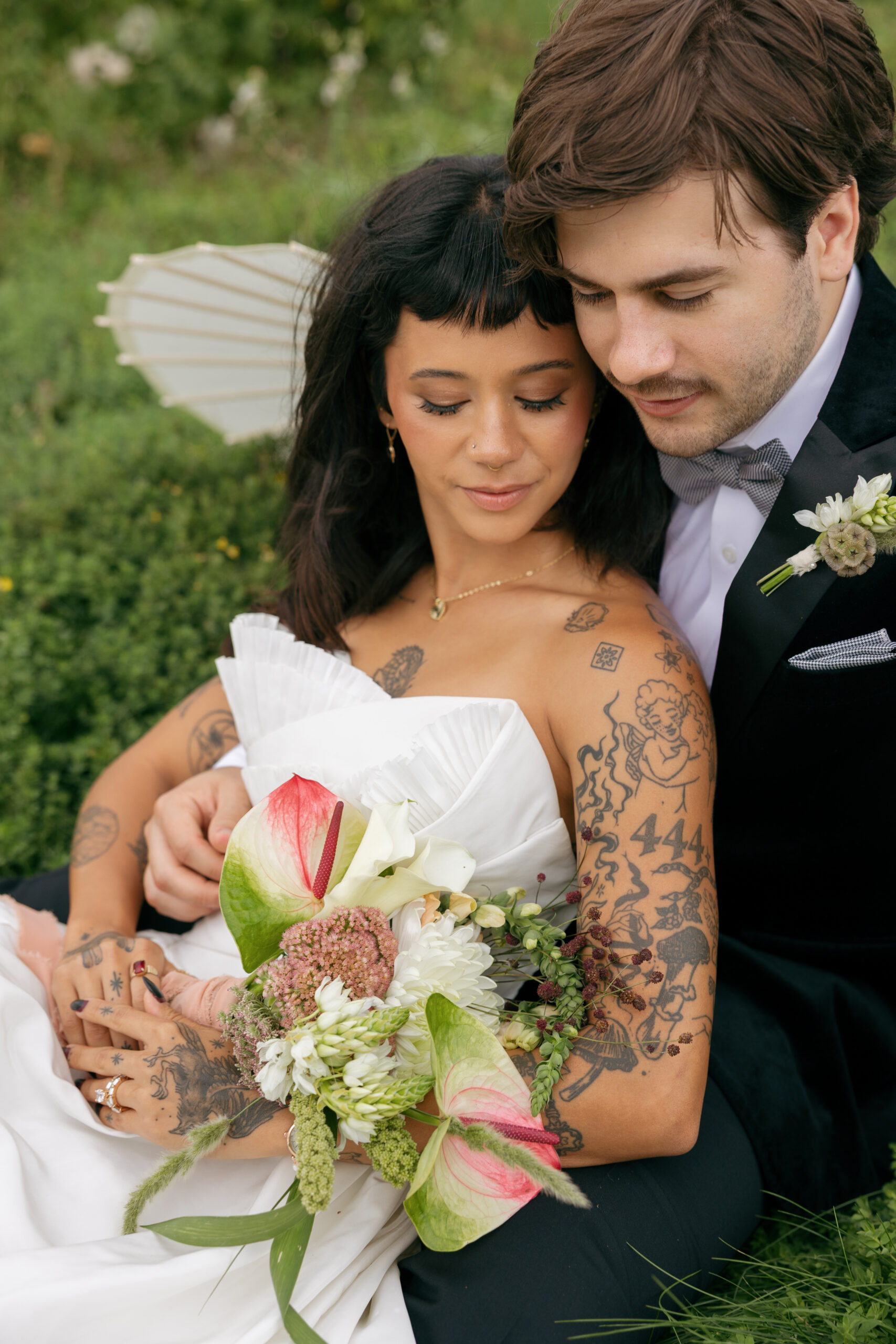 Couple embracing with a calla lily and anthurium bouquet from our seasonal wedding flowers October collection