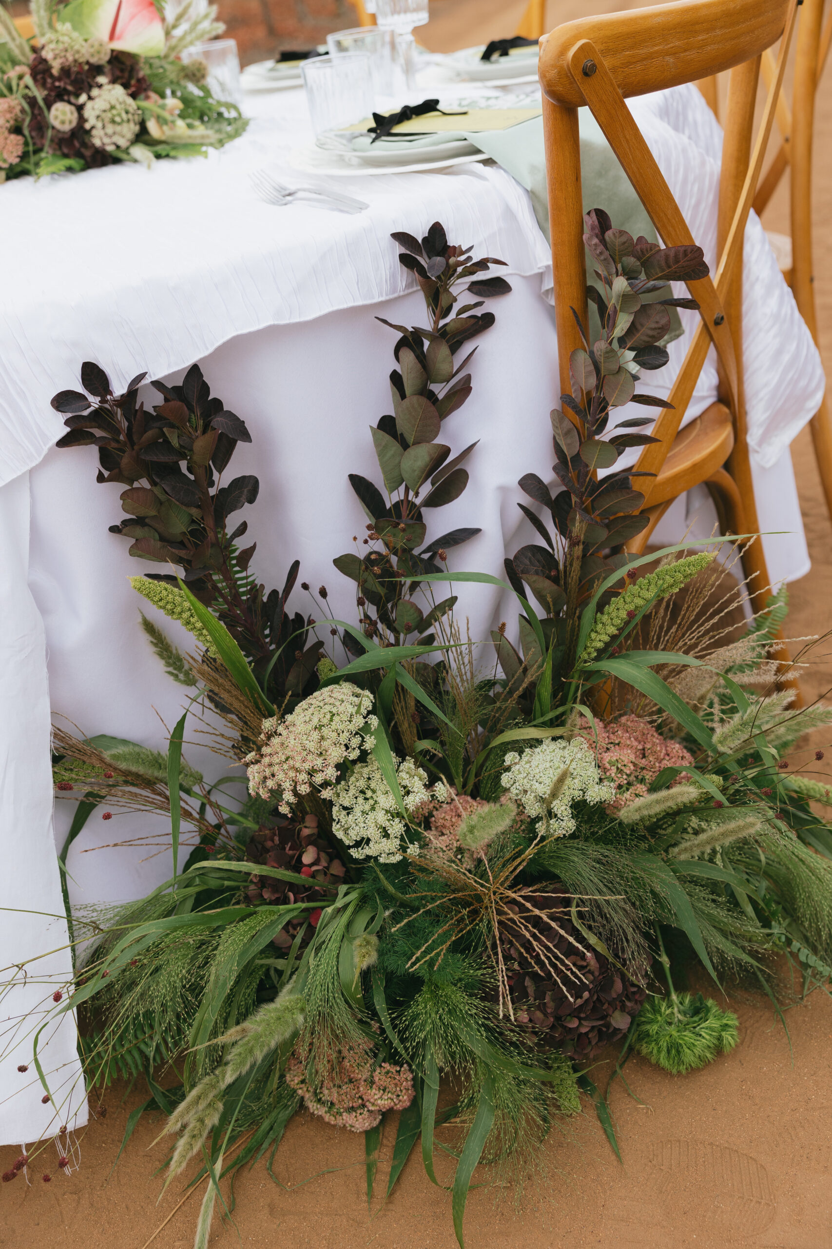 Burgundy smoke bush and Queen Anne's lace styled along a reception tablescape